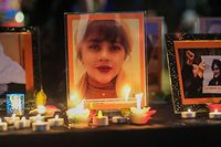 Candles and pictures of Mahsa Amini are placed at a memorial during a candlelight vigil for Mahsa Amini who died in custody of Iran's morality police, in Los Angeles, California, September 29, 2022. - Amini's death after her arrest by Iran's morality police has sparked a wave of unrest since the 22-year-old died on September 16 after her arrest for allegedly failing to observe Iran's strict dress code for women. The street violence has led to the deaths of dozens of people -- mostly protesters but also members of the security forces -- and hundreds of arrests. (Photo by RINGO CHIU / AFP)