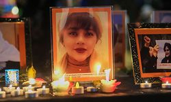 Candles and pictures of Mahsa Amini are placed at a memorial during a candlelight vigil for Mahsa Amini who died in custody of Iran's morality police, in Los Angeles, California, September 29, 2022. - Amini's death after her arrest by Iran's morality police has sparked a wave of unrest since the 22-year-old died on September 16 after her arrest for allegedly failing to observe Iran's strict dress code for women. The street violence has led to the deaths of dozens of people -- mostly protesters but also members of the security forces -- and hundreds of arrests. (Photo by RINGO CHIU / AFP)