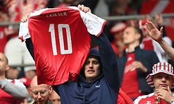 TOPSHOT - A Denmark fan holds up Denmark's midfielder Christian Eriksen's jersey during the UEFA EURO 2020 Group B football match between Denmark and Finland at the Parken Stadium in Copenhagen on June 12, 2021. (Photo by Jonathan NACKSTRAND / POOL / AFP)