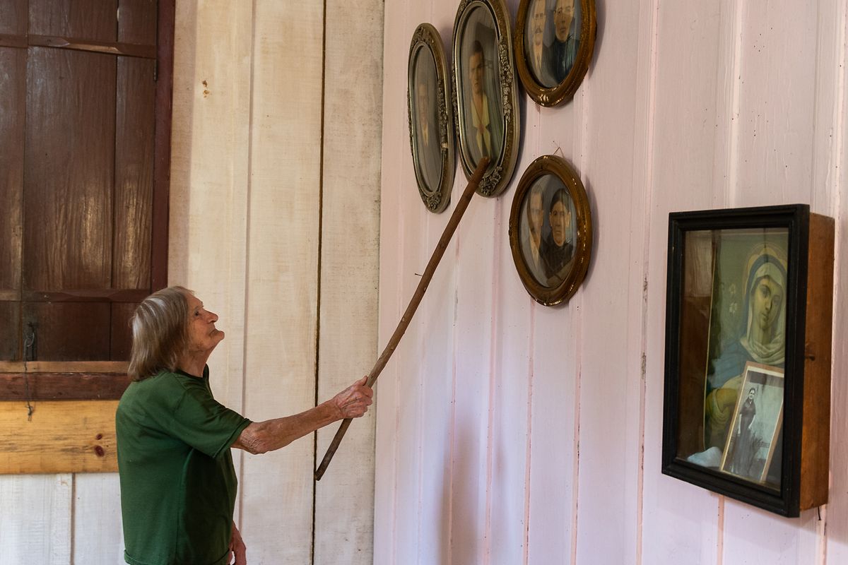 Adélia Bohatchuk zeigt mit einem Stock Bilder ihrer Vorfahren, die im 19. Jahrhundert aus der Ukraine ausgewandert sind. Adélia wohnt seit ihrem ersten Lebensjahr in einem typisch ukrainischen Haus in Prudentópolis.