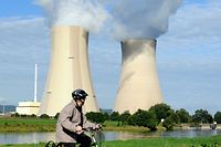 (FILES) In this file photo taken on August 19, 2010 a cyclist passes a nuclear power plant on the banks of the river Weser in Grohnde, northern Germany. - Germany will shut down three nuclear power plants - Brokdorf, Grohnde and Gundremmingen - amid one of the worst European energy crises in history on December 31, 2021. (Photo by PETER STEFFEN / DPA / AFP)