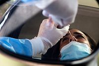 A woman undergoes a swab test for coronavirus at a drive-through testing site of the Santa Maria della Pieta hospital in Rome on August 18, 2020. - On August 16, Italy suspended its discos and ordered the mandatory wearing of masks from 6:00pm (1600 GMT) to 6:00am to clamp down on the spread of infection among young people, less than a month before the restart of school. (Photo by Tiziana FABI / AFP)
