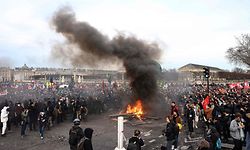 TOPSHOT - Protesters stand around burning barriers during a demonstration on Place de la Concorde after the French government pushed a pensions reform through parliament without a vote, using the article 49,3 of the constitution, in Paris on March 16, 2023. - The French president on March 16 rammed a controversial pension reform through parliament without a vote, deploying a rarely used constitutional power that risks inflaming protests. The move was an admission that his government lacked a majority in the National Assembly to pass the legislation to raise the retirement age from 62 to 64. (Photo by Thomas SAMSON / AFP)