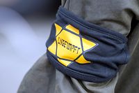 ARCHIV - 05.04.2021, Berlin: Bei einer Demonstration gegen die Einschränkungen durch die Pandemie-Maßnahmen der Bundesregierung trägt ein Teilnehmer eine Armbinde mit einem gelben Stern, der an einen Judenstern erinnern soll, mit der Aufschrift «Ungeimpft». Nach der Zunahme des Antisemitismus in der Corona-Krise wollen Institutionen in Bayern auch im Jahr 2022 gegen die Vorurteile vorgehen. (zu dpa «Der neue Antisemitismus und die alte Brunnenvergifter-Legende») Foto: Christophe Gateau/dpa +++ dpa-Bildfunk +++