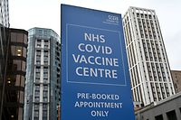 An NHS COVID-19 sign is pictured outside a Covid-19 vaccination centre in Wembley, northwest London, on January 19, 2021. - Britain on January 18 extended its coronavirus vaccination campaign to people over the age of 70, as new, tougher restrictions for all arrivals to the country came into force. (Photo by JUSTIN TALLIS / AFP)
