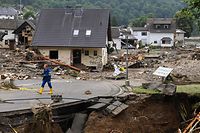 TOPSHOT - A man walk on a partially slipped road amid destroyed houses after the floods caused major damage in Schuld near Bad Neuenahr-Ahrweiler, western Germany, on July 16, 2021. - Devastating floods have torn through entire villages and killed at least 129 people in Europe, most of them in western Germany where stunned emergency services were still combing the wreckage on July 16, 2021. (Photo by CHRISTOF STACHE / AFP)