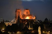 TOPSHOT - Firefighters douse flames rising from the roof at Notre-Dame Cathedral in Paris on April 15, 2019. - A major fire broke out at the landmark Notre-Dame Cathedral in central Paris sending flames and huge clouds of grey smoke billowing into the sky, the fire service said. The flames and smoke plumed from the spire and roof of the gothic cathedral, visited by millions of people a year, where renovations are currently underway. (Photo by Bertrand GUAY / AFP)