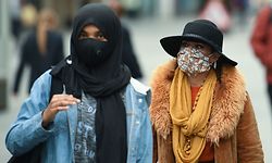 Women wear face masks or coverings due to the COVID-19 pandemic, as they walk in Liverpool, north west England on October 2, 2020, following the announcement of new local restrictions for certain areas in the northwest of the country, due to a resurgence of novel coronavirus cases. - The British government on Thursday extended lockdowns to Liverpool and several other towns in northern England, effectively putting more than a quarter of the country under tighter coronavirus restrictions. Health Secretary Matt Hancock said limits on social gatherings would be extended to the Liverpool City region, which has a population of about 1.5 million. (Photo by Oli SCARFF / AFP)