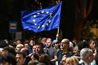 A person holds a European Union flag during a rally in support of Georgia's membership to the European Union in Tbilisi on July 3, 2022. - People rallied in Georgian capital on July 3 demanding that the government resign over its failure to formally secure candidacy for membership of the European Union. (Photo by Vano SHLAMOV / AFP)