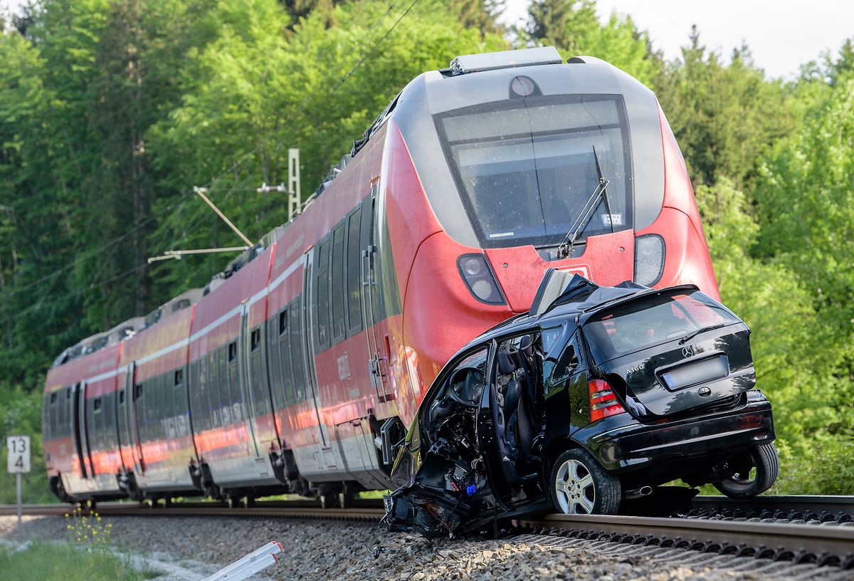 Ein Auto liegt vor einem Zug auf den Gleisen. An einem Bahnübergang an der Bahnstrecke von Tutzing nach Kochel kam es zu einem Unfall zwischen Zug und PKW. Bei dem Unfall starben zwei Personen.