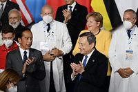 Indonesian President Joko Widodo (L), Italy's Prime Minister, Mario Draghi (R), German outgoing Chancellor Angela Merkel (Rear R) and Indian Prime Minister Narendra Modi pose during a group photo of world leaders with health workers at the G20 of World Leaders Summit on October 30, 2021 at the convention center "La Nuvola" in the EUR district of Rome. (Photo by Filippo MONTEFORTE / AFP)