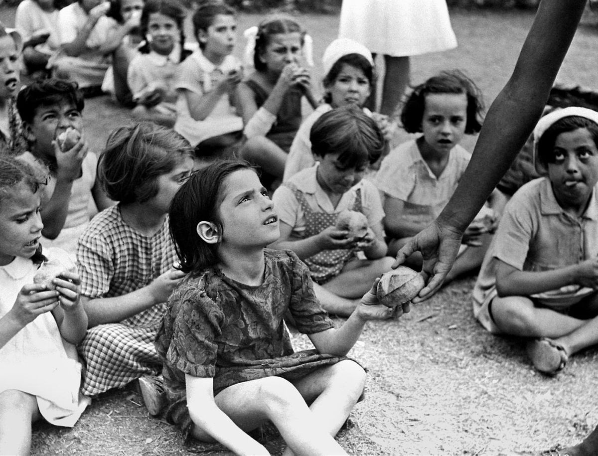 1945 erhalten Kinder im Campo Dei Cavalieri Di Colombo in der Via Aurelia in Rom Lebensmittel.