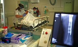 17.05.2020, Großbritannien, Blackburn: Die Radiologen Emma Parker und Gemma Ainsworth in Schutzkleidung bereiten in der Röntgenabteilung des Royal Blackburn Lehrkrankenhaus einen Patienten auf eine Untersuchung vor. Foto: Hannah Mckay/PA Wire/dpa +++ dpa-Bildfunk +++