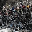TOPSHOT - This picture taken from the Greek side of the Greece-Turkey border near Kastanies, shows migrants waiting on the Turkish side on March 2, 2020. - Greece was on a state of alert on March 1, 2020 as it faced an influx of thousands of migrants seeking to cross the border from Turkey, with locals fearing a new immigration crisis. More than 13,000 migrants have gathered on the Turkish side of the river which runs 200 kilometres (125 miles) along the frontier and separates them from Greece and therefore the European Union. The flow of migrants from Turkey has triggered EU fears of a re-run of the 2015 migrant emergency when Greece became the main EU entry point for a million migrants, most of them refugees fleeing the Syrian civil war. (Photo by Sakis MITROLIDIS / AFP)