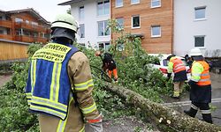 05.06.2022, Allgäu, Immenstadt: Feuerwehrleute sind nach einem Unwetter im Einsatz und räumen umgestürzte Bäume beiseite. Foto: Lisa Willert/dpa +++ dpa-Bildfunk +++