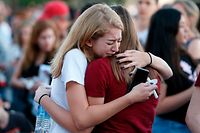 (FILES) In this file photo taken on February 15, 2018 Mourners grieve as they await the start of  a candlelight vigil for victims of the Marjory Stoneman Douglas High School shooting in Parkland, Florida. 
There have been renewed calls for stricter gun control in the United States following the shooting deaths last week of 14 students and three adults at a Florida high school. The White House has said following the Florida school shooting that President Donald Trump supports efforts to improve the federal background check system for gun buyers. / AFP PHOTO / RHONA WISE