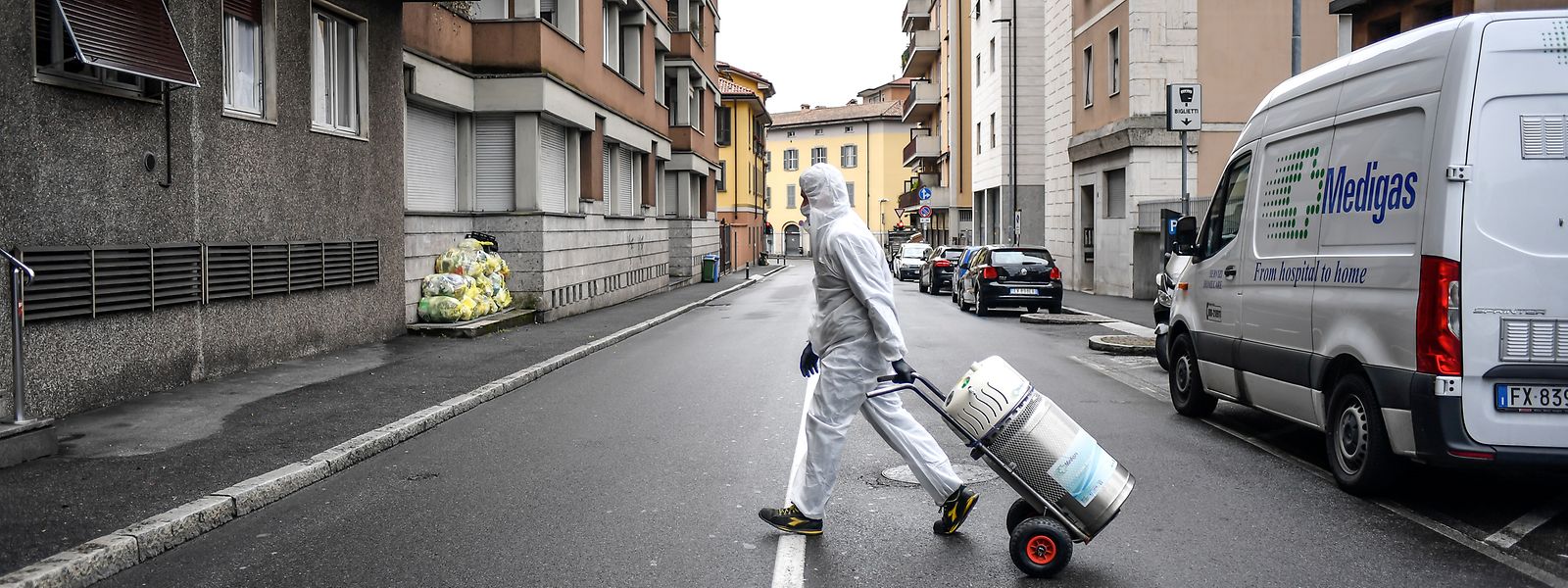 Bergamo: Ein Arbeiter im Schutzanzug liefert eine Sauerstoffflasche an ein Zuhause.