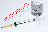 (FILES) This file picture taken on November 18, 2020 shows a syringe and a bottle reading "Vaccine Covid-19" next to the Moderna biotech company logo. - US biotechnology firm Moderna on January 25, 2021 said lab studies showed its Covid-19 vaccine would remain protective against variants of the coronavirus first identified in the United Kingdom and South Africa. "The study showed no significant impact" on the level of neutralizing antibodies elicited against the UK variant, B.1.1.7. (Photo by JOEL SAGET / AFP) / -- IMAGE RESTRICTED TO EDITORIAL USE - STRICTLY NO COMMERCIAL USE --