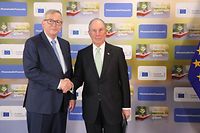 European commission president Jean-Claude Juncker (L) shakes hands with united nations secretary-general envoy for climate action Michael Bloomberg during the green finance conference at the European commission headquarters on March 22, 2018, in Brussels. / AFP PHOTO / Ludovic MARIN