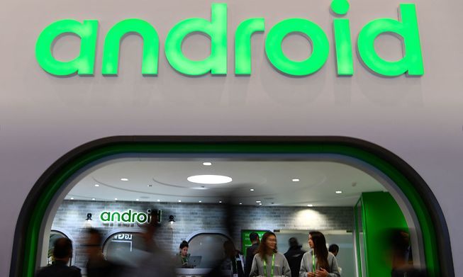 Visitors walk past the Android stand at the Mobile World Congress in Barcelona on 25 February 2019