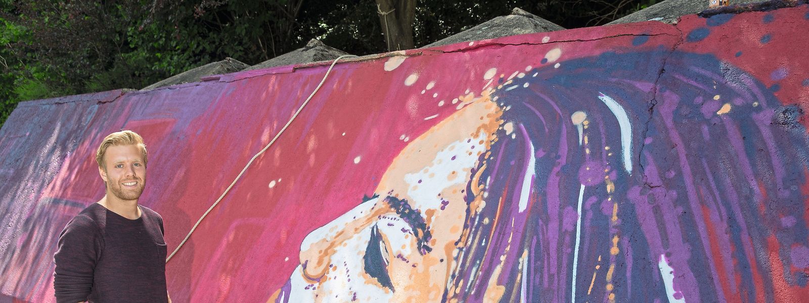 Kunstsprayer Raphaël Gindt in Aktion in Herserange: Das Frauenporträt auf der Stützmauer ist eine Auftragsarbeit im Rahmen des Festivals „Kufa’s Urban Art“.