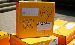 Briefträger haben Yellowboxen, gesammelt um die Masken zu verschicken.