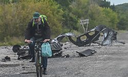 A man rides a bicycle past parts of a destroyed armored vehicle on a road in Balakliya, Kharkiv region, on September 10 , 2022, amid the Russian invasion of Ukraine. - Ukrainian forces said on September 10, 2022 they had entered the town of Kupiansk in eastern Ukraine, dislodging Russian troops from a key logistics hub in a lightning counter-offensive that has seen swathes of territory recaptured. (Photo by Juan BARRETO / AFP)