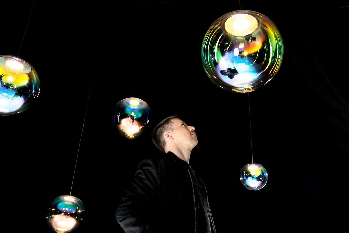 Seifenblasen waren die Inspiration für die Leuchten Iris von Designer Sebastian Scherer. Die Oberfläche des kugelförmigen, mundgeblasenen Leuchtenkörpers schimmert auch genauso.