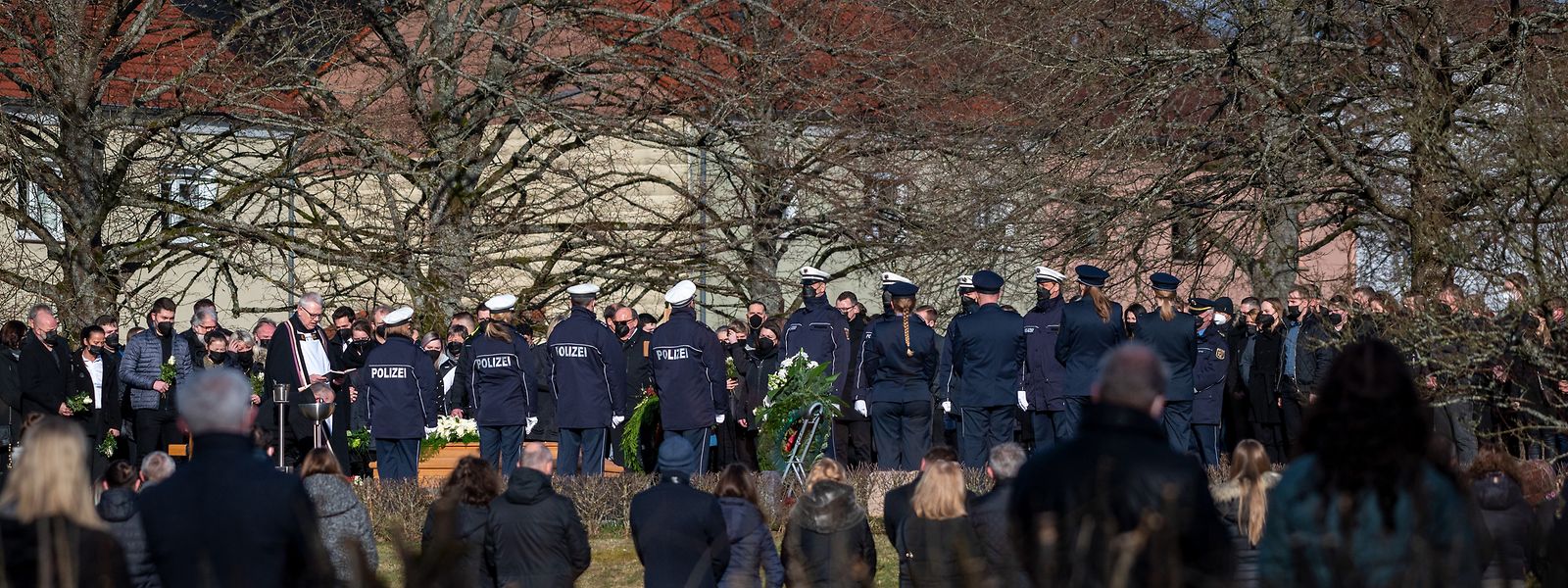 Trauergäste, darunter viele Polizisten, stehen am Grab des Polizeikommissars, der mit einer Kollegin am 31. Januar 2022 während einer Fahrzeugkontrolle bei Kusel in Rheinland-Pfalz erschossen wurde. 
