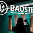 A woman is reflected on a wall with a company logo of Baosteel Group at an office in Shanghai, July 24, 2011.   REUTERS/Stringer/File Photo    CHINA OUT. NO COMMERCIAL OR EDITORIAL SALES IN CHINA  