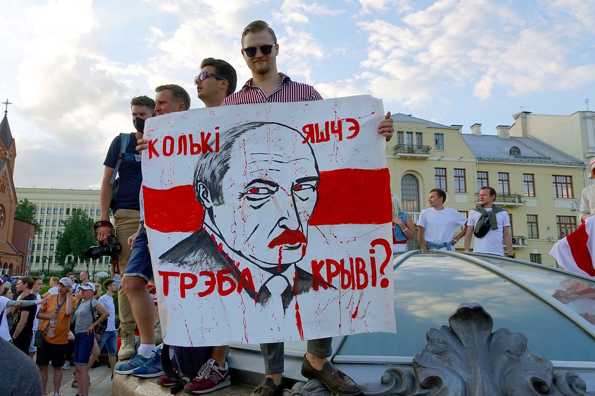 "Wie viel Blut braucht es noch?" steht auf dem Plakat mit dem Gesicht von Machthaber Lukaschenko, das ein junger Mann auf dem Unabhängigkeitsplatz hält. 