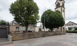 Das Schulhaus (links) soll einem sozialen Bauprojekt weichen. Die Gegner aus dem Dorf wollen dies vor Gericht verhindern.