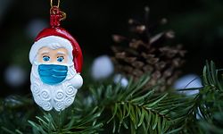 This picture taken in Paris on December 22, 2020 shows a Christmas Santa Claus decoration, with a protective mask. (Photo by JOEL SAGET / AFP)