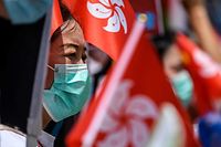 Pro-China supporters display Chinese and Hong Kong flags during a rally near the government headquarters in Hong Kong on June 30, 2020, as China passed a sweeping national security law for the city. - China passed a sweeping national security law for Hong Kong, a historic move that critics and many western governments fear will smother the finance hub's freedoms and hollow out its autonomy. (Photo by Anthony WALLACE / AFP)