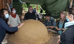 Die innere Schicht ist fertig, weitere Lagen aus Lehm folgen. Annick Feipel vom Generatiounsgaart (2. von rechts) freut sich auf Pizza mit Holzfeuerduft.