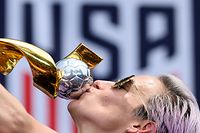 TOPSHOT - USA women's soccer player Megan Rapinoe kisses the trophy in front of the City Hall after the ticker tape parade for the women's World Cup champions on July 10, 2019 in New York. - Amid chants of "equal pay," "USA" and streams of confetti, the World Cup-winning US women's soccer team was feted by tens of thousands of adoring fans with a ticker-tape parade in New York on Wednesday. (Photo by Johannes EISELE / AFP)