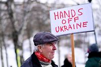 A demonstrator holds a placard reading "Hands off Ukraine" as he takes part in a protest against Russia's Ukraine policy, outside the Russian embassy in Stockholm, Sweden, on February 23, 2022. (Photo by Paul WENNERHOLM / TT NEWS AGENCY / AFP) / Sweden OUT