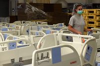An employee of Czech hospital beds maker Linet walks past the beds to be used in the Covid-19 field hospital at Letnany on October 20, 2020 in the Linet factory in the village of Zelevcice, 30km south-east of Prague. (Photo by Michal Cizek / AFP)