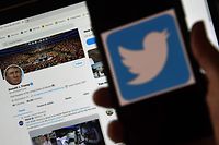 In this photo illustration, a Twitter logo is displayed on a mobile phone with President Trump's Twitter page shown in the background on May 27, 2020, in Arlington, Virginia. - US President Donald Trump threatened Wednesday to shutter social media platforms after Twitter for the first time acted against his false tweets, prompting the enraged Republican to double down on unsubstantiated claims and conspiracy theories. Twitter tagged two of Trump's tweets in which he claimed that more mail-in voting would lead to what he called a "Rigged Election" this November. (Photo by Olivier DOULIERY / AFP)