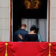 (FILES) In this file photo taken on July 10, 2018 Britain's Meghan, Duchess of Sussex (R) puts her hand on Britain's Prince Harry, Duke of Sussex's back as they leave the balcony of Buckingham Palace in London, after watching a military fly-past to mark the centenary of the Royal Air Force (RAF). - Britain's Queen Elizabeth II on January 13, 2020, said Prince Harry and his wife Meghan would be allowed to split their time between Britain and Canada while their future is finalised. The couple said last week they wanted to step back from the royal frontline, catching the family off guard and forcing the monarch to convene crisis talks about the pair's future roles. (Photo by Tolga AKMEN / AFP)