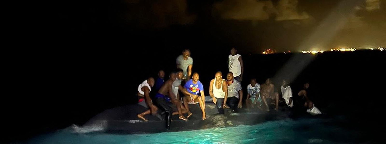 Immer mehr Haitianer fliehen aus ihrem Land. Auf diesem Bild, das von der Royal Bahamas Defence Force zur Verfügung gestellt wurde, sitzen Überlebende eines gekenterten Migrantenboots auf dem umgestürzten Schiff vor der Küste der Insel New Providence, Bahamas. 