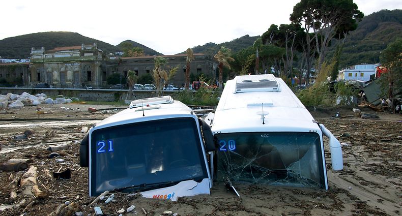 TOPSHOT - Damaged tourist busess are seen on the port of Casamicciola on November 27, 2022, following heavy rains that caused a landslide on the island of Ischia, southern Italy. - Italian rescuers were searching for a dozen missing people on the southern island of Ischia after a landslide killed at least one person, as the government scheduled an emergency meeting. A wave of mud and debris swept through the small town of Casamicciola Terme early Saturday morning, engulfing at least one house and sweeping cars down to the sea, local media and emergency services said. (Photo by Eliano IMPERATO / AFP)