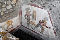 dpatopbilder - HANDOUT - 11.10.2019, Italien, Pompeji: Zwei Gladiatoren sind auf einem Fresko zu sehen. Es zeigt zwei Kämpfer, der eine mit einem Schutzschild und einem Schwert. Der andere geht blutend zu Boden. Wahrscheinlich schmückte es einen Raum, der von Gladiatoren besucht wurde, weil es dort Prostituierte gab, teilte die Ausgrabungsstätte südlich von Neapel am Freitag (11.10.2019) mit. Die Stadt Pompeji wurde 79 n. Chr. bei einem Ausbruch des Vesuvs verschüttet. Foto: Ausgrabungsstätte Pompeji/Ministero per i beni e le attività culturali e per il turismo/dpa - ACHTUNG: Nur zur redaktionellen Verwendung im Zusammenhang mit der aktuellen Berichterstattung und nur mit vollständiger Nennung des vorstehenden Credits +++ dpa-Bildfunk +++