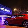 A building of the assembly plant of US car maker Ford is illuminated with the lettering 'E-Mobilitaet' (E-Mobility) in Cologne, western Germany, on February 17, 2021. - US auto giant Ford said on February 17, 2021 it was investing one billion dollars in Germany in a bid to make all of its passenger vehicles sold in Europe electric by 2030. The company said in a statement that "by mid-2026, 100 percent of Ford's passenger vehicle range in Europe will be zero-emissions capable, all-electric or plug-in hybrid, and will be completely all-electric by 2030". It said it would upgrade its assembly plant in Cologne, the home of Ford Europe, with a USD 1-billion (830-million-euro) investment to advance the company's "all-electric future". (Photo by Oliver Berg / POOL / AFP)
