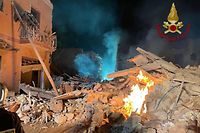 HANDOUT - 11.12.2021, Italien, Ravanusa: Rauch und Flammen kommen aus den Trümmern eines Wohnhauses. Nach einer Explosion ist ein Wohnhaus auf Sizilien eingestürzt - mehrere Menschen werden vermisst. Unter den etwa zwölf Vermissten seien auch Kinder und eine Schwangere, berichtete die italienische Nachrichtenagentur Ansa. Das Haus in Ravanusa stürzte am Samstagabend ein, wie die Feuerwehr erklärte. Foto: Feuerwehr Ravanusa/via Twitter/dpa +++ dpa-Bildfunk +++