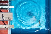 26.06.2019, Bayern, Straubing: Ein Mann taucht im Freibad nach einem Sprung ins Wasser zum Beckenrand (Luftaufnahme mit Drohne). Foto: Armin Weigel/dpa +++ dpa-Bildfunk +++