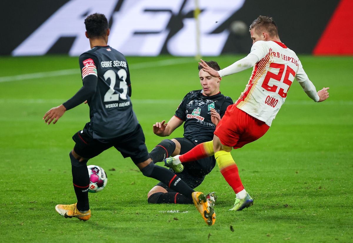 Leipzigs Dani Olmo trifft gegen Bremen um Theodor Gebre Selassie (l.) und Marco Friedl zum 2:0.