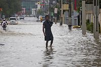 A man stands on a flooded street after the passage of the Tropical Storm Grace in Santo Domingo, on August 16, 2021. - The US National Hurricane Center (NHC) warned that it is possible that flash floods and landslides may occur today in the Dominican Republic and Haiti due to Grace, which at 8.00 hours (12.00 GMT) was 125 miles (200 kilometers) east of the Haitian capital, Port-au-Prince. (Photo by Erika SANTELICES / AFP)
