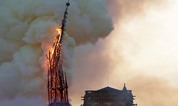 The steeple of the landmark Notre-Dame Cathedral collapses as the cathedral is engulfed in flames in central Paris on April 15, 2019. - A huge fire swept through the roof of the famed Notre-Dame Cathedral in central Paris on April 15, 2019, sending flames and huge clouds of grey smoke billowing into the sky. The flames and smoke plumed from the spire and roof of the gothic cathedral, visited by millions of people a year. A spokesman for the cathedral told AFP that the wooden structure supporting the roof was being gutted by the blaze. (Photo by Geoffroy VAN DER HASSELT / AFP)