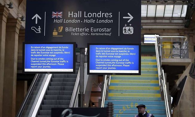 A screen displays information regarding suspended Eurostar traffic near the "Hall London" at Gare du Nord international railway station in Paris on January 17, 2015, after smoke was detected in the Channel Tunnel. Traffic was suspended in both directions in the Channel Tunnel between Britain and France on January 17 after a lorry fire, authorities said. AFP PHOTO / LIONEL BONAVENTURE